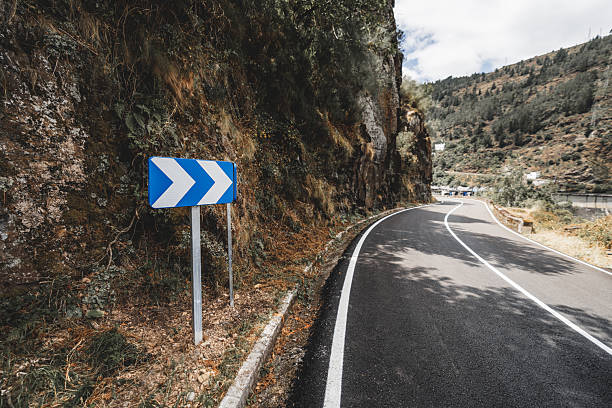 istock Curved mountain road with sign 2228075382