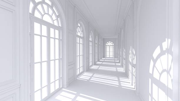 A classic corridor lined with tall arched windows and fanlights, where sunlight casts rhythmic shadows along the bright, elegant passageway.