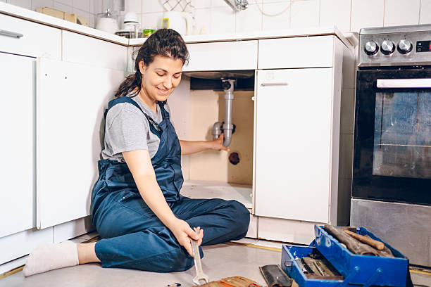 istock Female plumber repairing pipes in kitchen 2228078971