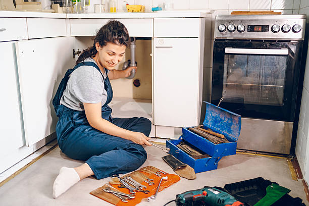 istock Female plumber repairing pipes in kitchen 2228079139