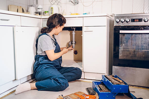 istock Female plumber repairing pipes in kitchen 2228079304