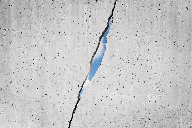 istock CRACKED CONCRETE WALL WITH SUNLIGHT SHINING THROUGH A DEEP FRACTURE, REVEALING BLUE SKY - Symbolic concept of hope, freedom, resilience, escape, and the way forward through adversity 2228086610