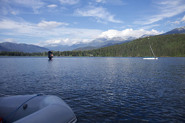 Distant view of young man sailing wing foil on lake, Whistler, British Columbia