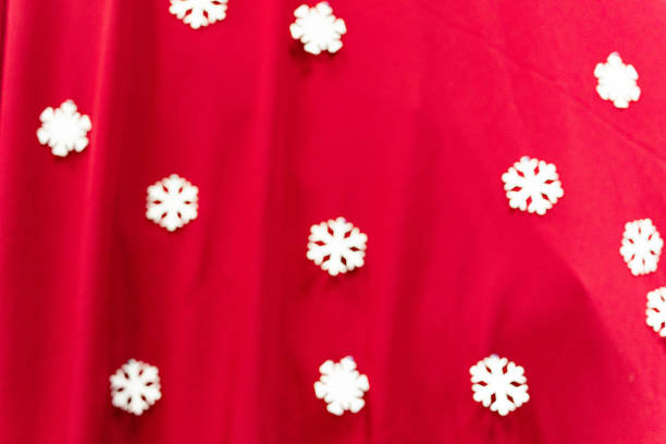 Blurred red Christmas background with white snowflakes.