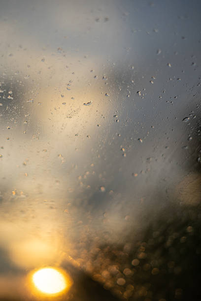 istock Golden hour rain, sun through wet window, moody atmosphere. 2228092882