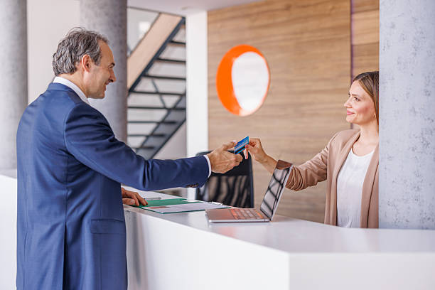 istock Businessman making a payment with credit card at hotel reception 2228092994