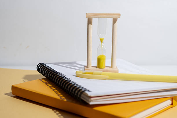 istock Time management concept: hourglass pencil and notepad. Time for school 2228093265