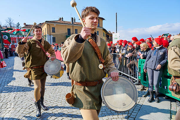 Ivrea, Italy - March 02, 2025: drummers in traditional costumes taking part to the grand historical parade of Ivrea Carnival featuring participants dressed in medieval costumes. They reenact various scenes from Ivrea's history, paying homage to the town's fight for independence.