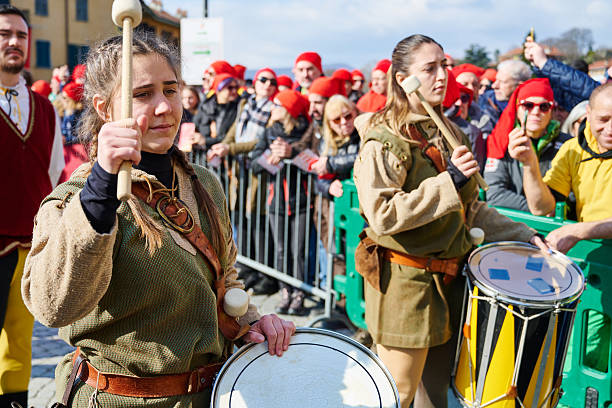 Ivrea, Italy - March 02, 2025: drummers in traditional costumes taking part to the grand historical parade of Ivrea Carnival featuring participants dressed in medieval costumes. They reenact various scenes from Ivrea's history, paying homage to the town's fight for independence.
