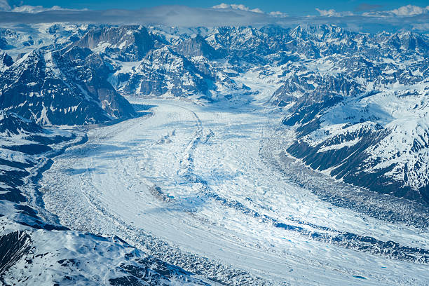 Broad high‑altitude panorama of snow‑covered ridges and glaciers, stretching across the Alaska Range. Dense layers of ice and rock create a wild labyrinth of frozen terrain.
