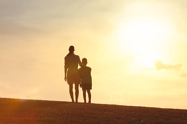 istock Mother's Day. Mother watching beautiful sunset with her son. 2228096520