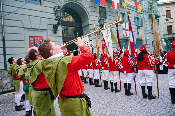 Ivrea, Italy - March 02, 2025: buglers in traditional costumes taking part to the grand historical parade of Ivrea Carnival featuring participants dressed in medieval costumes. They reenact various scenes from Ivrea's history, paying homage to the town's fight for independence.
