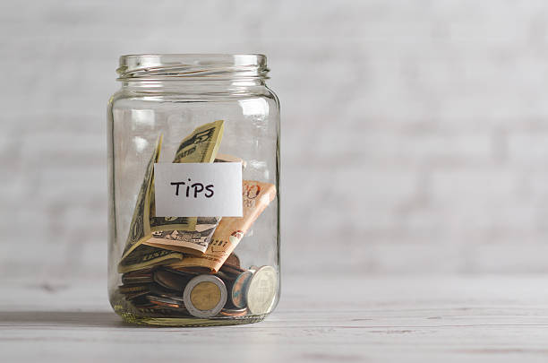 istock Tip jar on a white wooden countertop. 2228106510