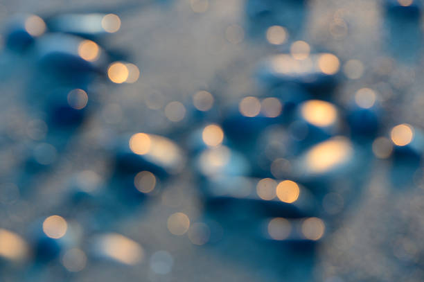 Out-of-focus sea stones and pebbles create a natural abstract background on a Mediterranean beach.
