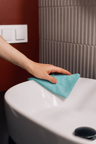 istock Cleaning a white bathroom sink in a modern apartment with a cloth 2228107157