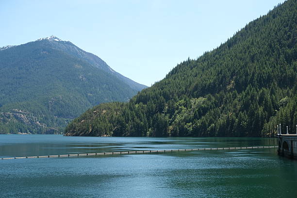 No Cascades National Park located in Washington State.  Scenic hiking trails, rivers, streams, waterfalls and lakes all with breath taking views backed by blue sky.  Green trees of all different kinds and a bed of ferns on the forest floor.