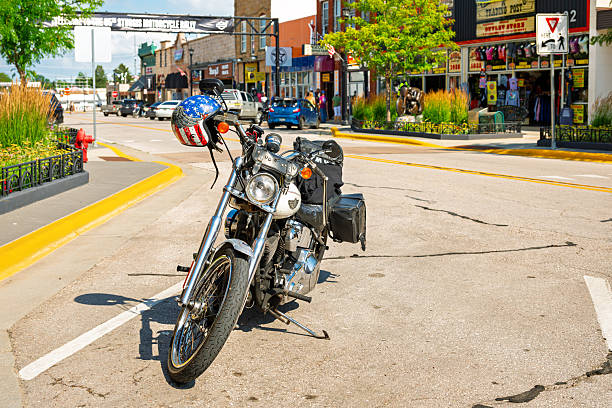 A classic 2004 Harley Davidson FLSTF Fat Boy motorcycle, with American Flag and Eagle helmet parked in downtown Sturgis, site of the annual motorcycle rally.