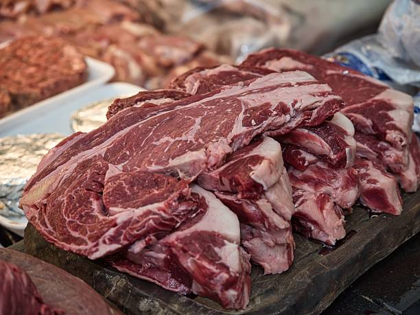 istock Raw beef steak on a white plate in a restaurant setting. Chef cutting fresh meat before cooking. 2228120217