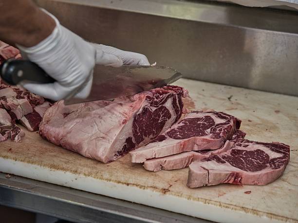 istock Raw beef steak on a white plate in a restaurant setting. Chef cutting fresh meat before cooking. 2228120248