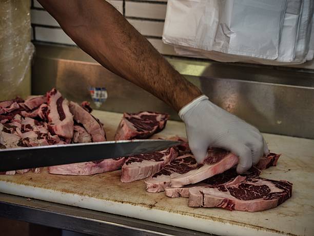 istock Raw beef steak on a white plate in a restaurant setting. Chef cutting fresh meat before cooking. 2228120258