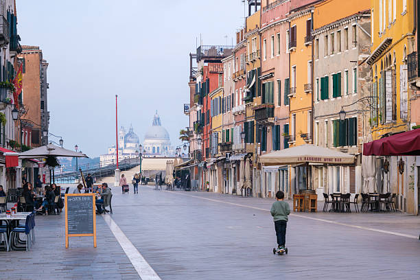 Venice,Italy: - November 7, 2013: Man walks away in an alley in Venice.He wears a trench coat and forms a silhouette.