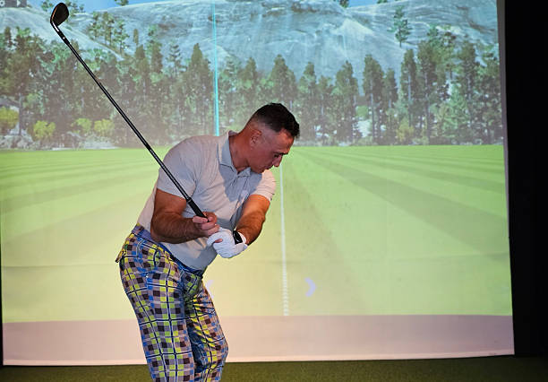 istock Golfer practicing swing indoors on a virtual driving range with scenic background 2228132392