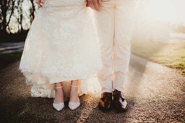 Bride and groom standing with each other outdoors at sunset