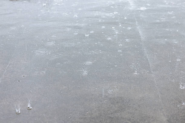 Textured full frame background. Rain drops on wet concrete pavement surface.