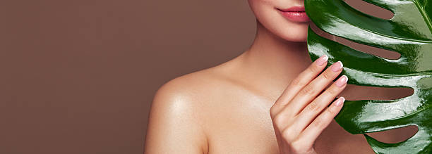 istock Close up woman face with green exotic leaf 2228140661