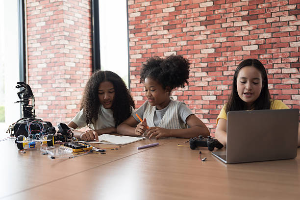 istock Group of diverse children training and learning robotics technology in classroom at school. Female students training AI robot training kit and mechatronics in robotics academy room 2228141819