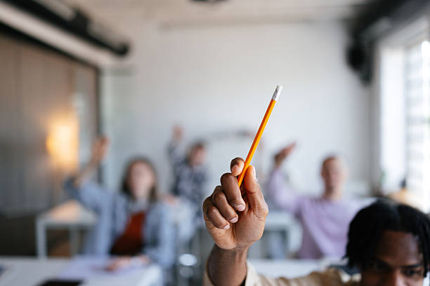 Close-Up of Student Holding Pencil in a Classroom Environment