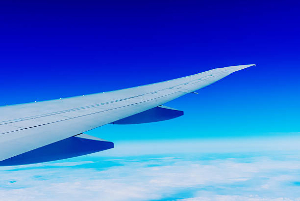 istock Airplane Wing Above the Clouds with Deep Blue Sky 2228150466