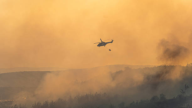 istock Fire fighting helicopter carry water bucket to extinguish the forest fire 2228150967