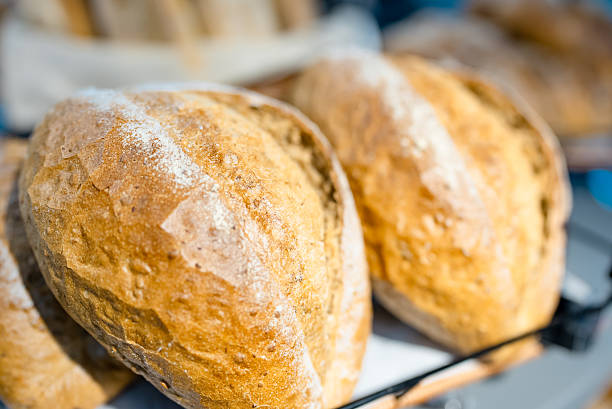 Artisanal bakery: Group of Fresh mixed breads, rolls and ingredients in a rustic kitchen.