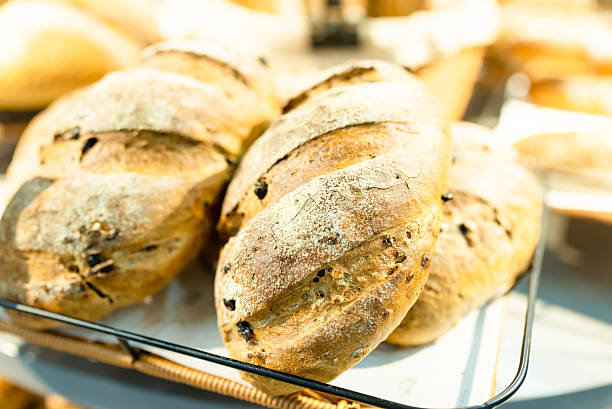 Artisanal bakery: Group of Fresh mixed breads, rolls and ingredients in a rustic kitchen.