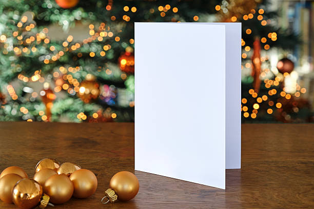 Standing blank greeting card mockup in front of a christmas tree