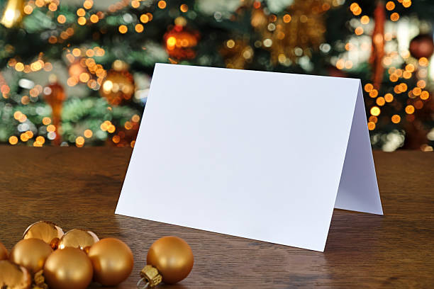 istock Standing blank greeting card mockup in front of a christmas tree 2228154428