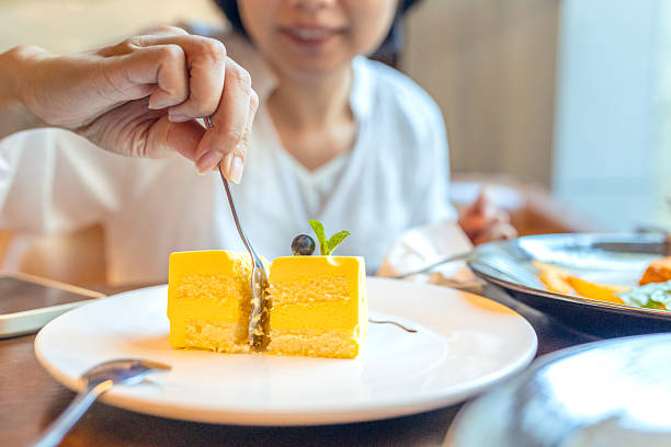 A woman tasting cake after dinner