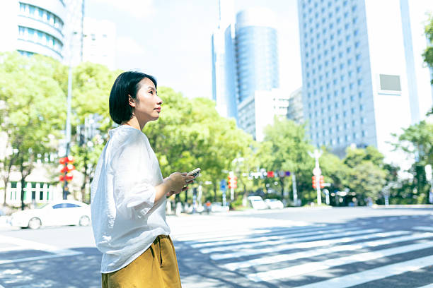 istock An Asian woman using a mobile phone in the city 2228154576