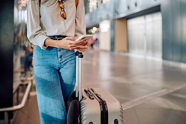 istock Woman using smartphone while waiting for flight at the airport 2228157107