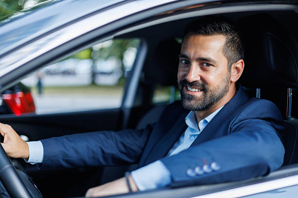 istock Confident businessman navigating vehicle, grinning and facing camera, radiating professional demeanor during urban commute 2228157234