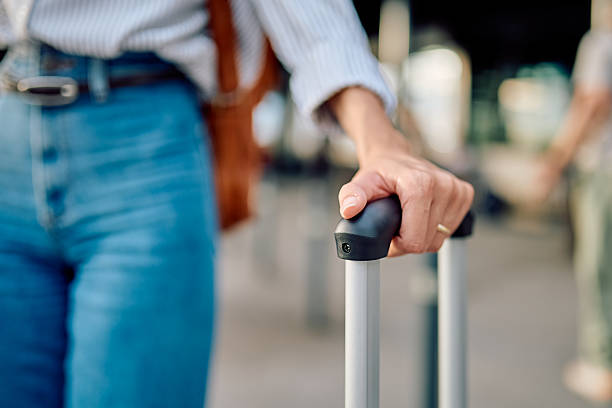 istock Woman pulling suitcase at the airport terminal 2228157310