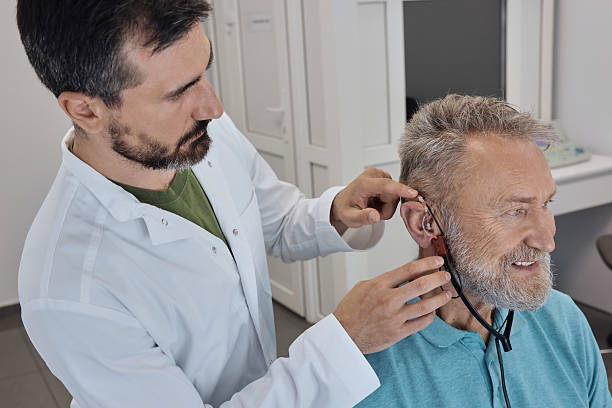 istock Audiologist setting a hearing aid for older client, ensuring optimal performance and comfort. Hearing clinic 2228159420