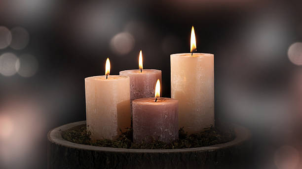 istock four burning wax candles for decoration isolated on blurred abstract background with defocused bokeh light 2228160501