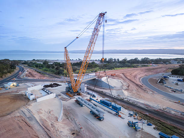 istock Large Construction Crane on Coastal Highway Development Project at Dusk 2228167878