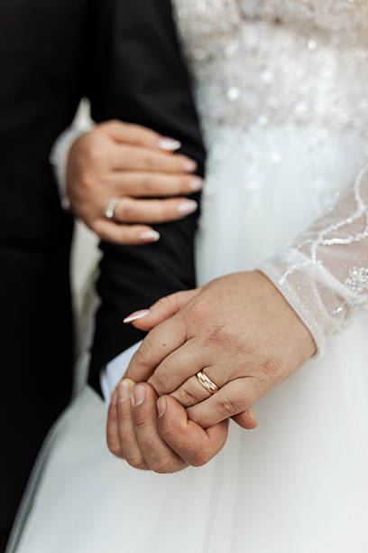 Heterosexual newlywed couple man and woman holding their hands