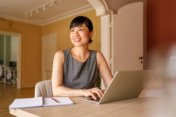 istock Thoughtful businesswoman looking away while working online over computer at desk in corporate office 2228169424