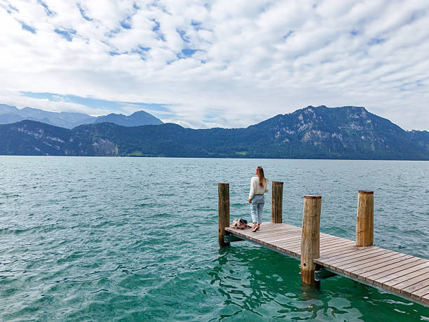 istock Woman Standing on Pier Over Mountain Lake 2228169768