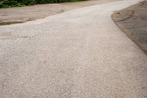 istock New asphalt road surface merging with old gravel road surface 2228171165