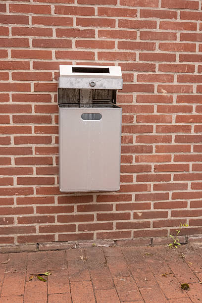 istock Metal trash can hanging on a red brick wall 2228171178